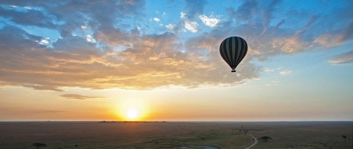 Ballon vor Sonne welche knapp über einem weitem flachen Horizont steht